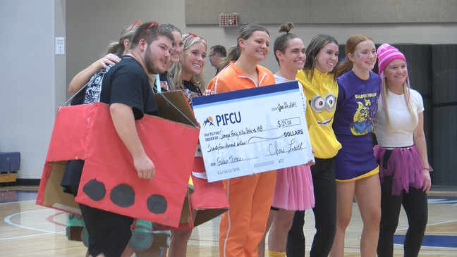 Students from LHS and CHS posed with a check from P1FCU, raising $24,000.{&nbsp;}{p}{/p}