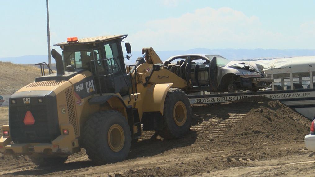 A bulldozer is putting a car onto a ramp for the monster truck to jump over.{&nbsp;}{p}{/p}