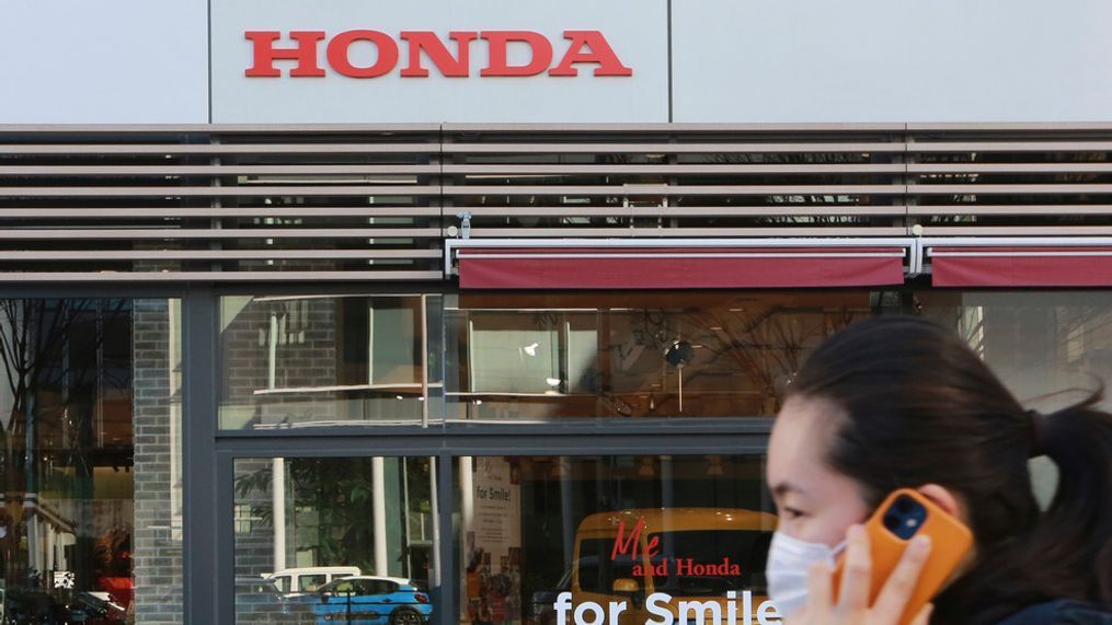 A woman wearing a face mask walks in front of a Honda Motor Co. showroom in Tokyo, Tuesday, Feb. 9, 2021.{&nbsp;} (AP Photo/Koji Sasahara)