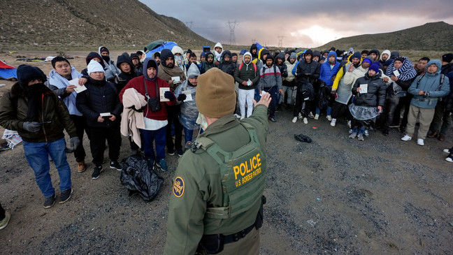 FILE - A Border Patrol agent asks asylum-seeking migrants to line up in a makeshift, mountainous campsite after the group crossed the border with Mexico, Friday, Feb. 2, 2024, near Jacumba Hot Springs, Calif. (AP Photo/Gregory Bull)