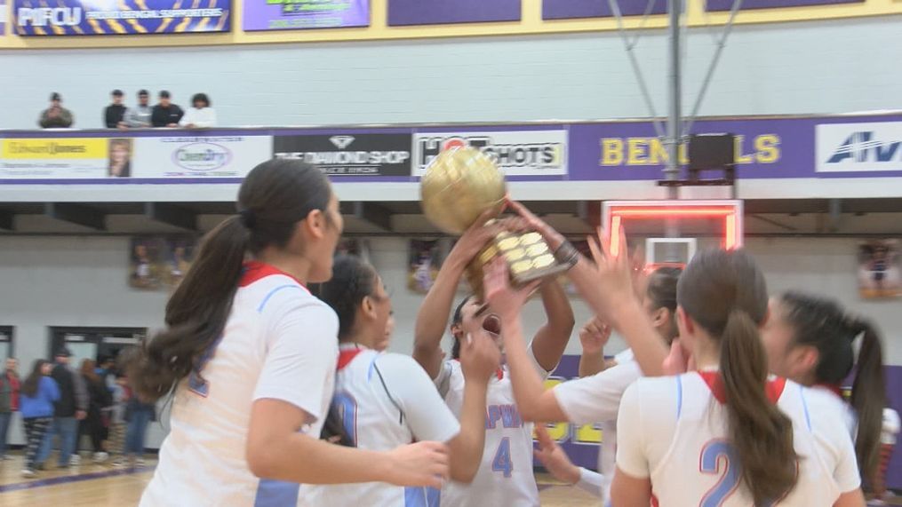 Lapwai girls basketball team celebrates mid court holding up the district tournament trophy.{&nbsp;}{p}{/p}